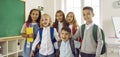 Banner with a group portrait of happy, funny school friends standing in the classroom