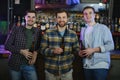 Friends having fun. Happy young men in casual wear drinking beer in pub. Royalty Free Stock Photo