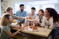 Friends Having Fun At Home In Kitchen Eating Homemade Pizzas Royalty Free Stock Photo