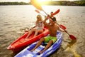 Friends Having Fun on Kayaks on Beautiful River or Lake at Sunset