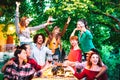 Friends having fun outdoor toasting red wine at garden party - Happy people eating and drinking together in farmhouse winery at Royalty Free Stock Photo