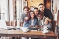 Friends having fun at restaurant. Three boys and two girls making selfie and laughing. On foreground boy holding smart Royalty Free Stock Photo