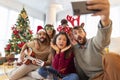 Friends having fun taking selfies while celebrating Christmas at home Royalty Free Stock Photo