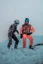 Friends having fun on top of the mountain while skiing/snowboarding.