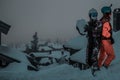 Friends having fun on top of the mountain while skiing/snowboarding.