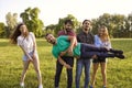 Friends having fun in wilderness during their summer trip in park. Group of people being silly outdoors