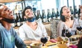 Friends having genuine fun at wine bar with open face mask - New normal lifestyle concept with happy people laughing together Royalty Free Stock Photo