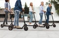 Friends having pleasant ride on motorized kick scooters Royalty Free Stock Photo