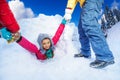 Friends helping girl to get out from the snow cave