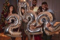 Friends holding balloons shaped as numbers 2022 representing the upcoming New Year Royalty Free Stock Photo