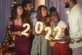 Friends holding illuminative numbers 2022 while celebrating New Year Royalty Free Stock Photo
