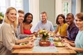 Friends At Home Sitting Around Table For Dinner Party Royalty Free Stock Photo