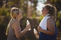 Friends interacting while having water after workout during obstacle course Royalty Free Stock Photo
