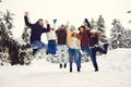Friends jumping in the snow in the park in winter Royalty Free Stock Photo