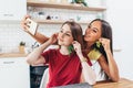 Friends in kitchen playing, taking selfie use fruits like earrings.