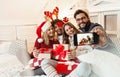 Friends on a large bed, exchanging Christmas presents; enjoying, happy Royalty Free Stock Photo