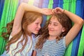 Friends are laughing on a hammock on a hot sunny day