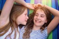 Friends are laughing on a hammock on a hot sunny day