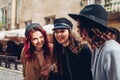 Friends laughing and having fun. Outdoor shot of three stylish young women talking on city street Royalty Free Stock Photo