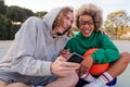 Friends laughing looking phone after play basket Royalty Free Stock Photo