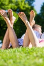 Friends laying with crossed legs in park