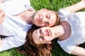 Friends laying side by side on park enjoying sun Royalty Free Stock Photo