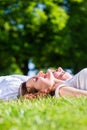 Friends laying side by side on park enjoying sun Royalty Free Stock Photo