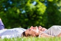 Friends laying side by side on park lawn Royalty Free Stock Photo