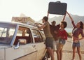 Friends Loading Luggage Onto Car Roof Rack Ready For Road Trip Royalty Free Stock Photo