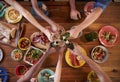 Friends making a toast at a dinner table, overhead, close up