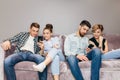 Friends with mobile phones are sitting on the couch and ignoring each others Royalty Free Stock Photo