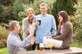 Friends Outdoors Enjoying Drink In Pub Garden