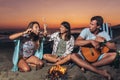 Friends partying on the beach with drinks. Happy young people having fun at beach party, celebrating together Royalty Free Stock Photo