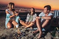 Friends partying on the beach with drinks. Happy young people having fun at beach party, celebrating together Royalty Free Stock Photo