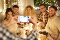 Friends photographing at christmas dinner party