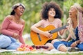 Friends, picnic in nature with guitar and smile or laugh as woman play music instrument. Black woman relax, happy Royalty Free Stock Photo