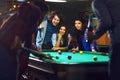 Friends play billiards.