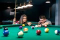 Friends playing billiard, man going hit a ball Royalty Free Stock Photo