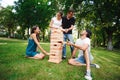 Friends playing board game. Giant Outdoor Block Game. Group game of physical skill with big blocks.