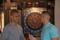 Friends playing darts indoors at bar Royalty Free Stock Photo