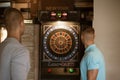 Friends playing darts indoors at bar Royalty Free Stock Photo