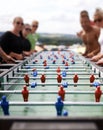 Friends playing with a foosball at a party for competition, fun skill or sports event. Celebration, activity and group Royalty Free Stock Photo