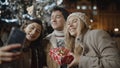 Friends taking selfie at xmas night at old town square. Friendship, christmas, new year, holiday concept. Filmed on RED