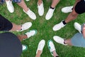 Friends putting their shoes together in a circle. Youth in white sneakers Royalty Free Stock Photo