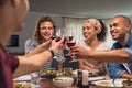 Friends raising toast during dinner Royalty Free Stock Photo