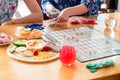 Friends ready to play sequence board game with color chips and playing cards. Hands dealing cards to Royalty Free Stock Photo