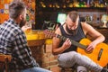 Friends relaxing in bar or pub. Hipster brutal bearded spend leisure with friend in bar. Real men leisure. Cheerful