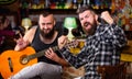 Friends relaxing in pub. Live music concert. Man play guitar in pub. Acoustic performance in pub. Hipster brutal bearded Royalty Free Stock Photo