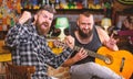 Friends relaxing in pub. Live music concert. Man play guitar in pub. Acoustic performance in pub. Hipster brutal bearded Royalty Free Stock Photo