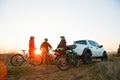 Friends Resting near Pickup Off Road Truck after Bike Riding in the Mountains at Sunset. Adventure and Travel Concept. Royalty Free Stock Photo